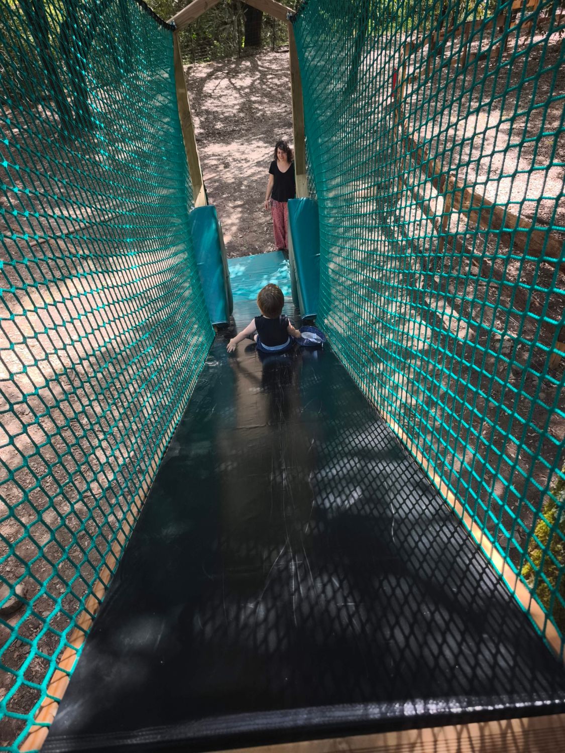 Enfant sur le toboggan du parcours de filets